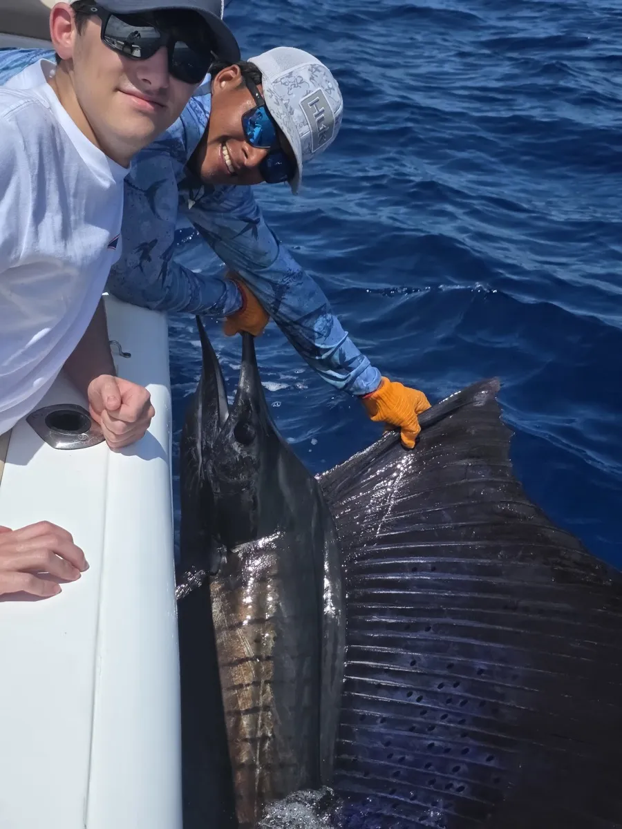 Guests with a sailfish at the boat off Playa Garza