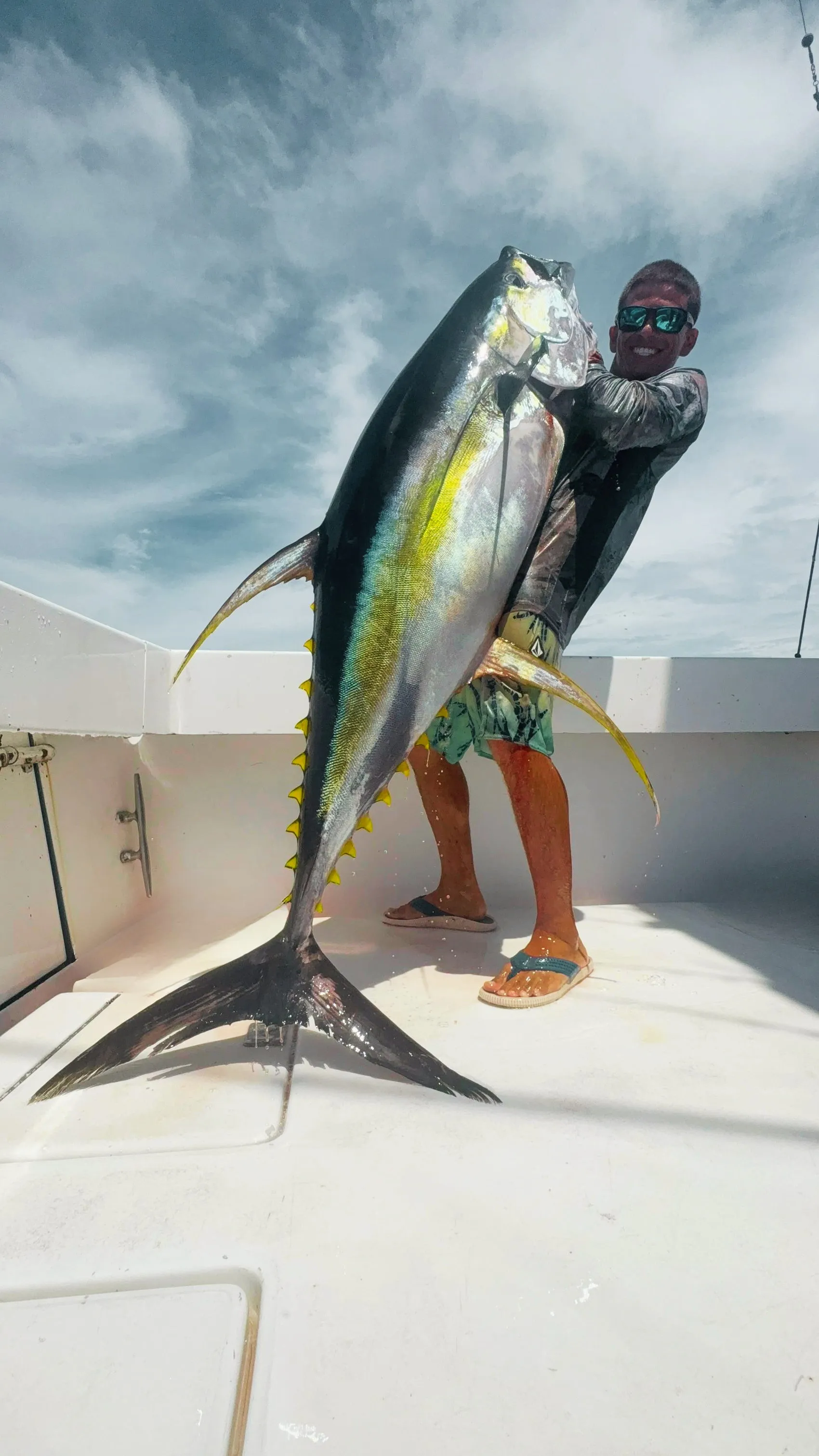 A yellowfin tuna held up on the deck
