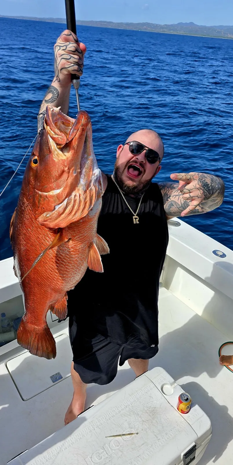 An angler holding a cubera snapper off Playa Garza