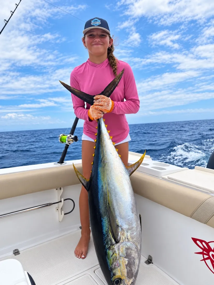 A young angler holding a large yellowfin tuna off Playa Garza