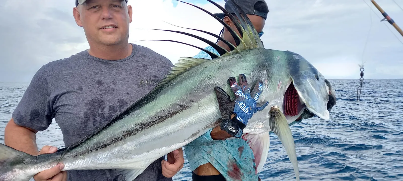 An angler holding up a roosterfish over the water