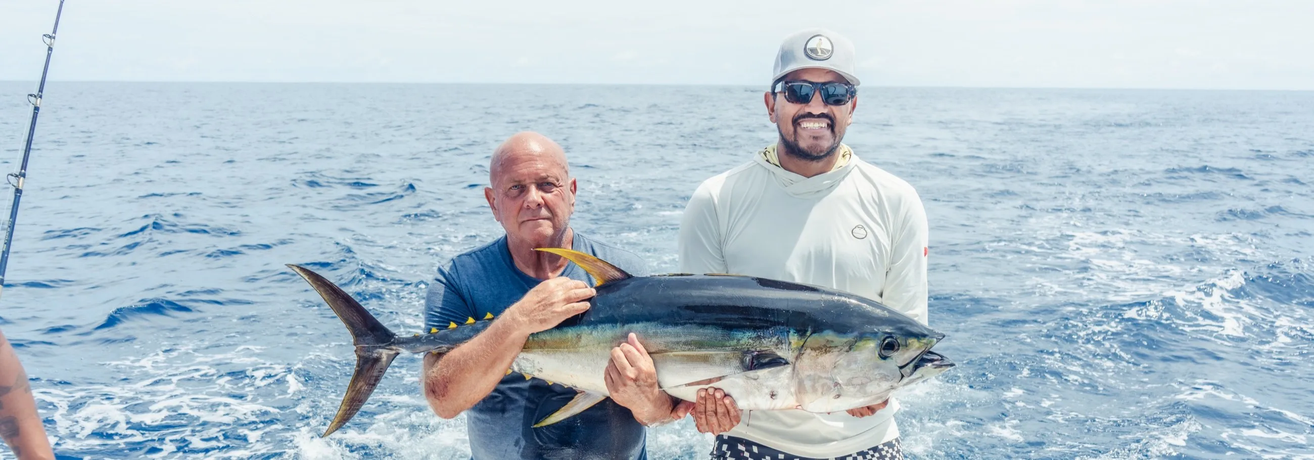 An angler holding a mahi mahi on the deck off Playa Garza