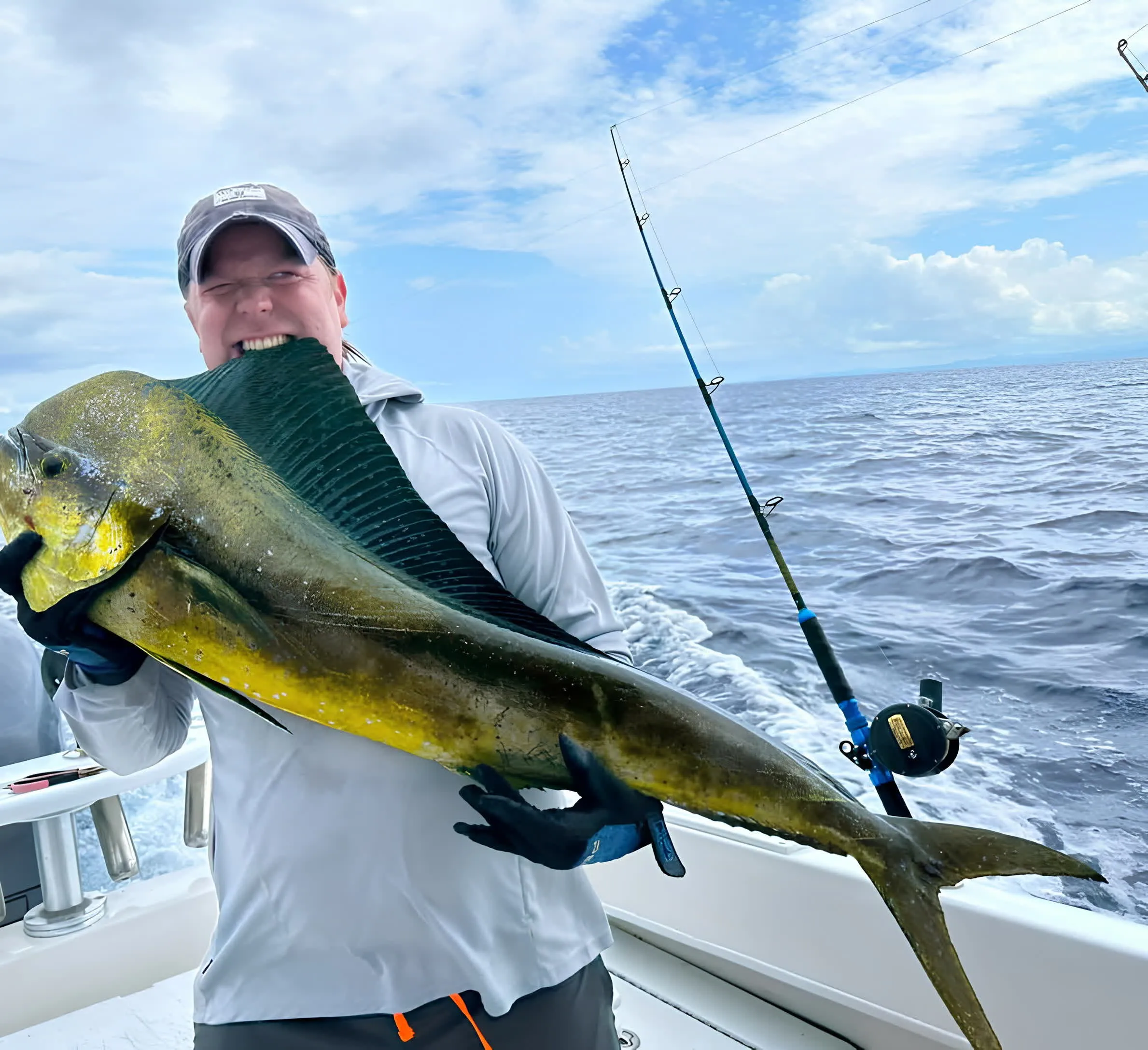 An angler holding up a mahi mahi aboard the boat off Playa Garza