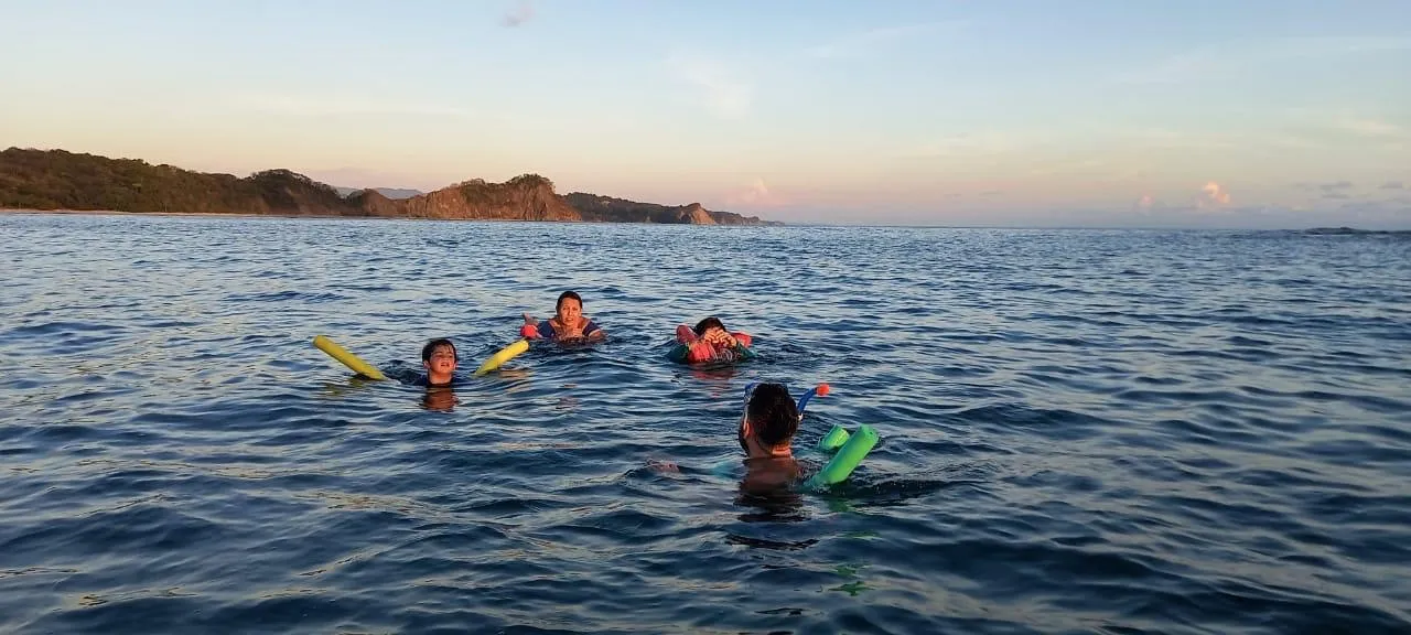 A family snorkeling off Playa Garza at golden hour