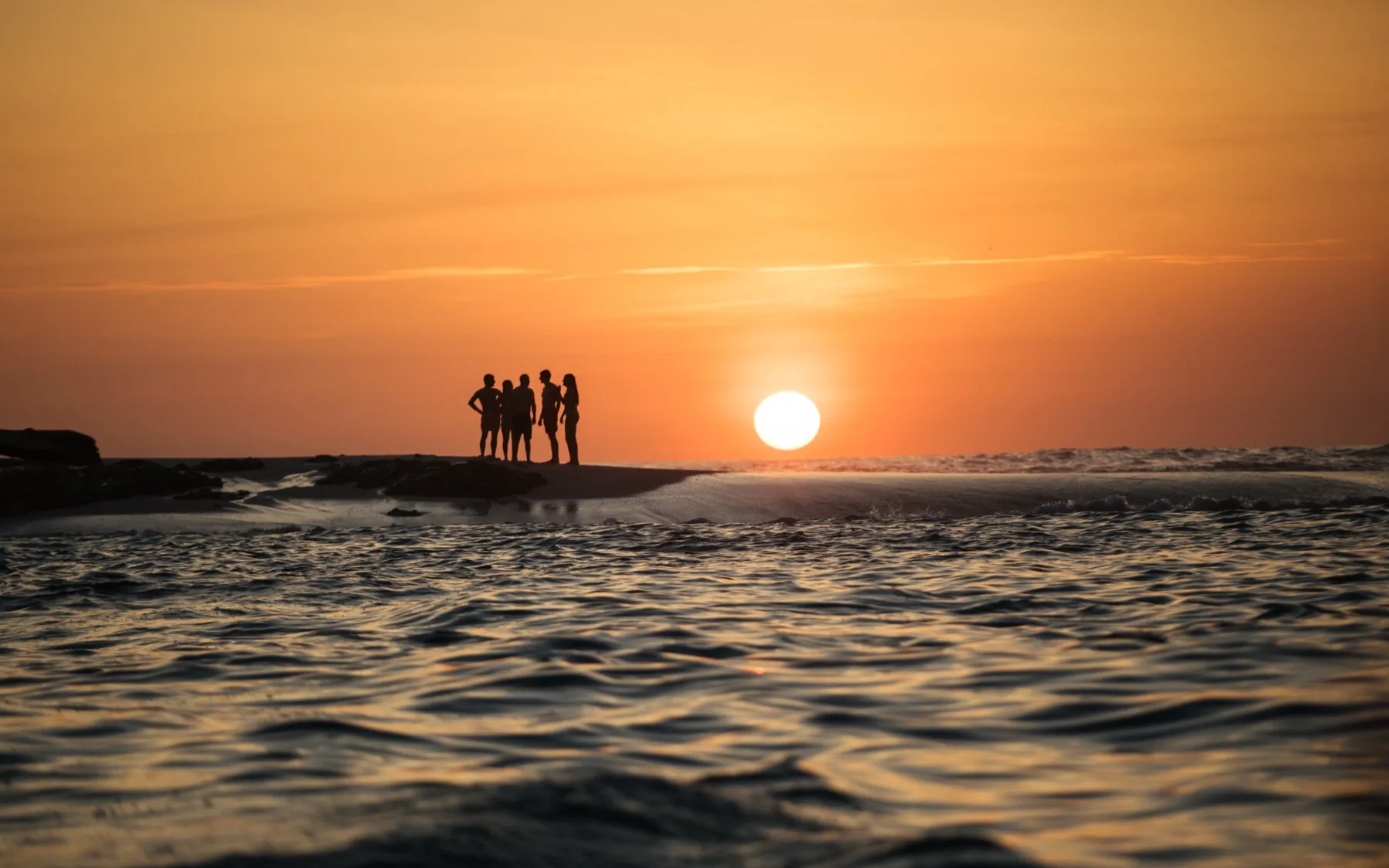 Guests on the sandbar at sunset off Playa Garza, Nosara