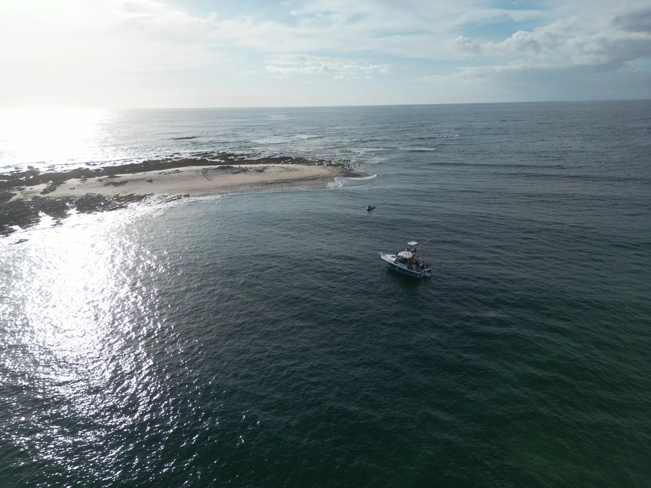 A Monkey Head boat off the reef at Playa Garza at golden hour, seen from the air