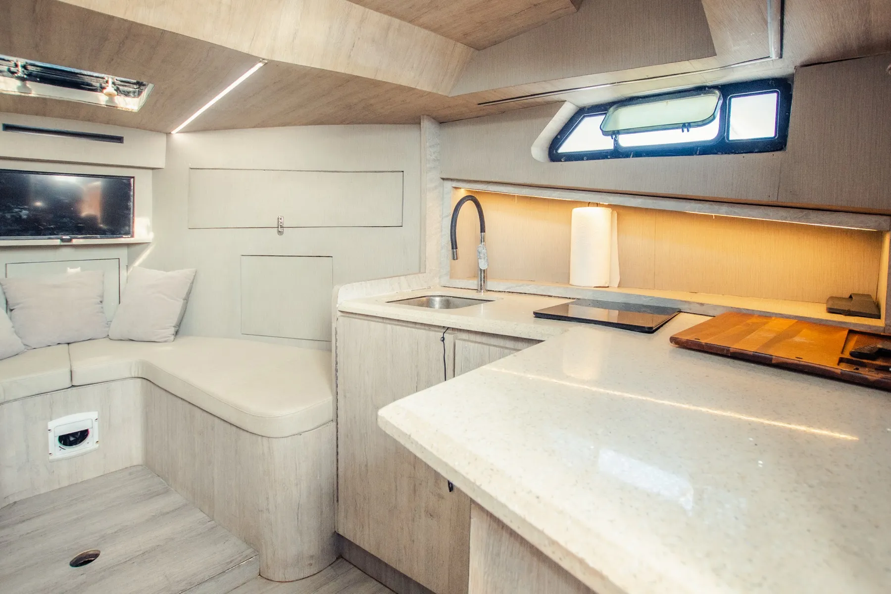 The air-conditioned cabin of the Osprey: cushioned seating, galley and sink