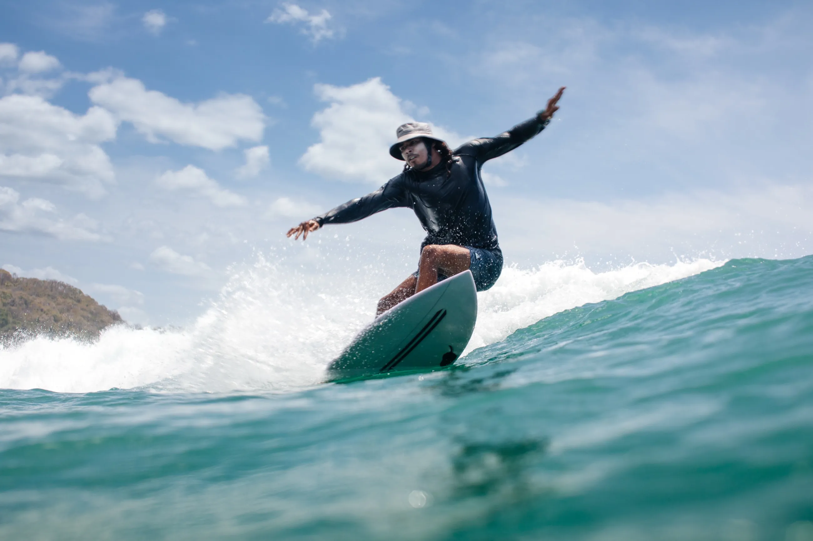 A surfer riding a wave off Playa Garza, Nosara
